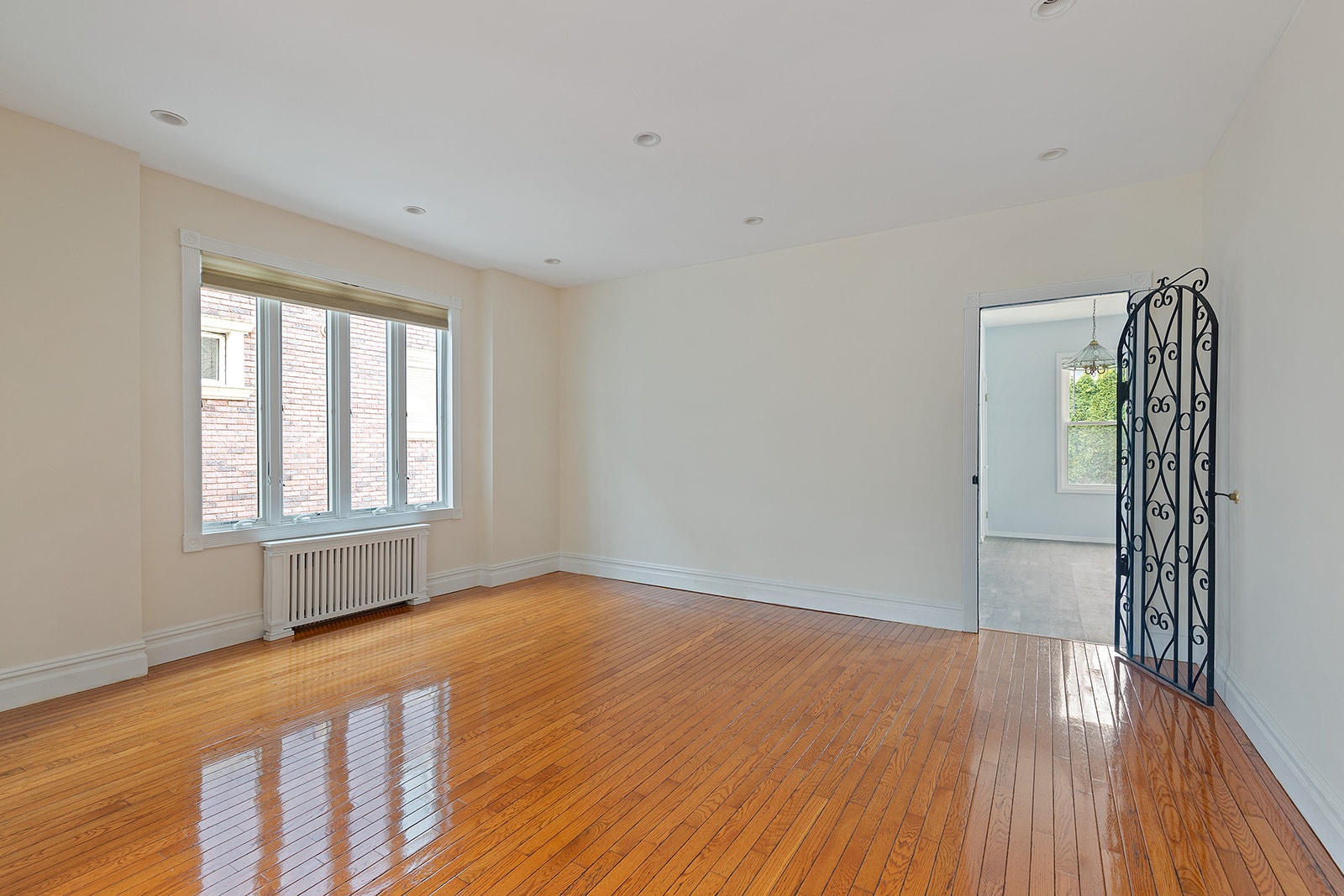 96 86th Street Brooklyn, NY 11209 - Photo 3 of 13 a view of an empty room with wooden floor and a window