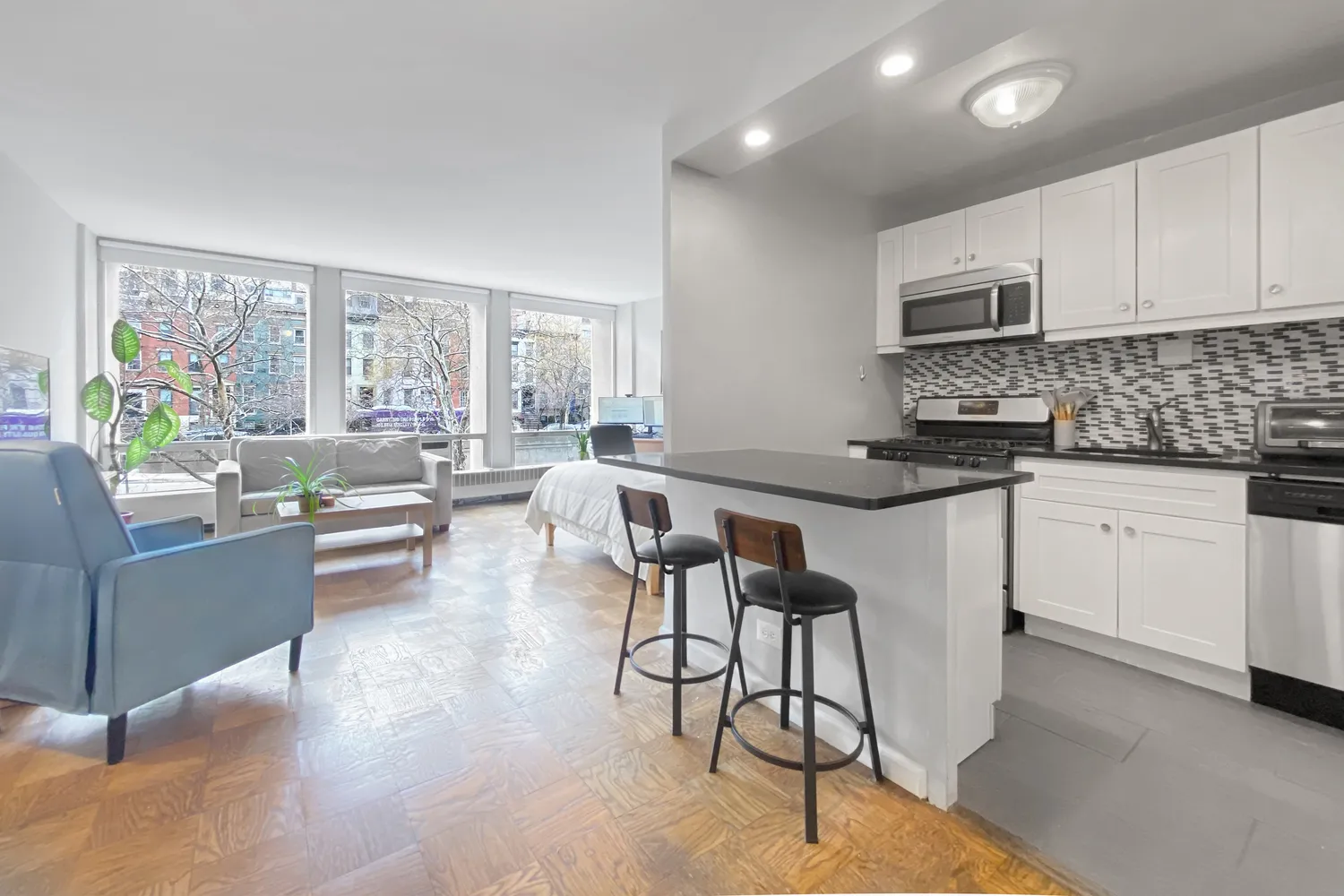 a kitchen with stainless steel appliances kitchen island granite countertop a stove and white cabinets