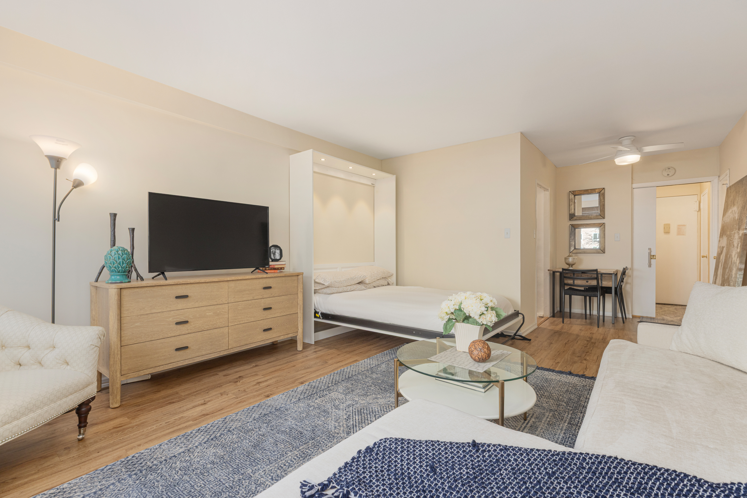 345 West 58th Street, Unit 4Y Manhattan, NY 10019 - Photo 4 of 12 a living room with furniture and a flat screen tv