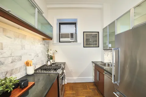 a kitchen with stainless steel appliances granite countertop a refrigerator and a stove