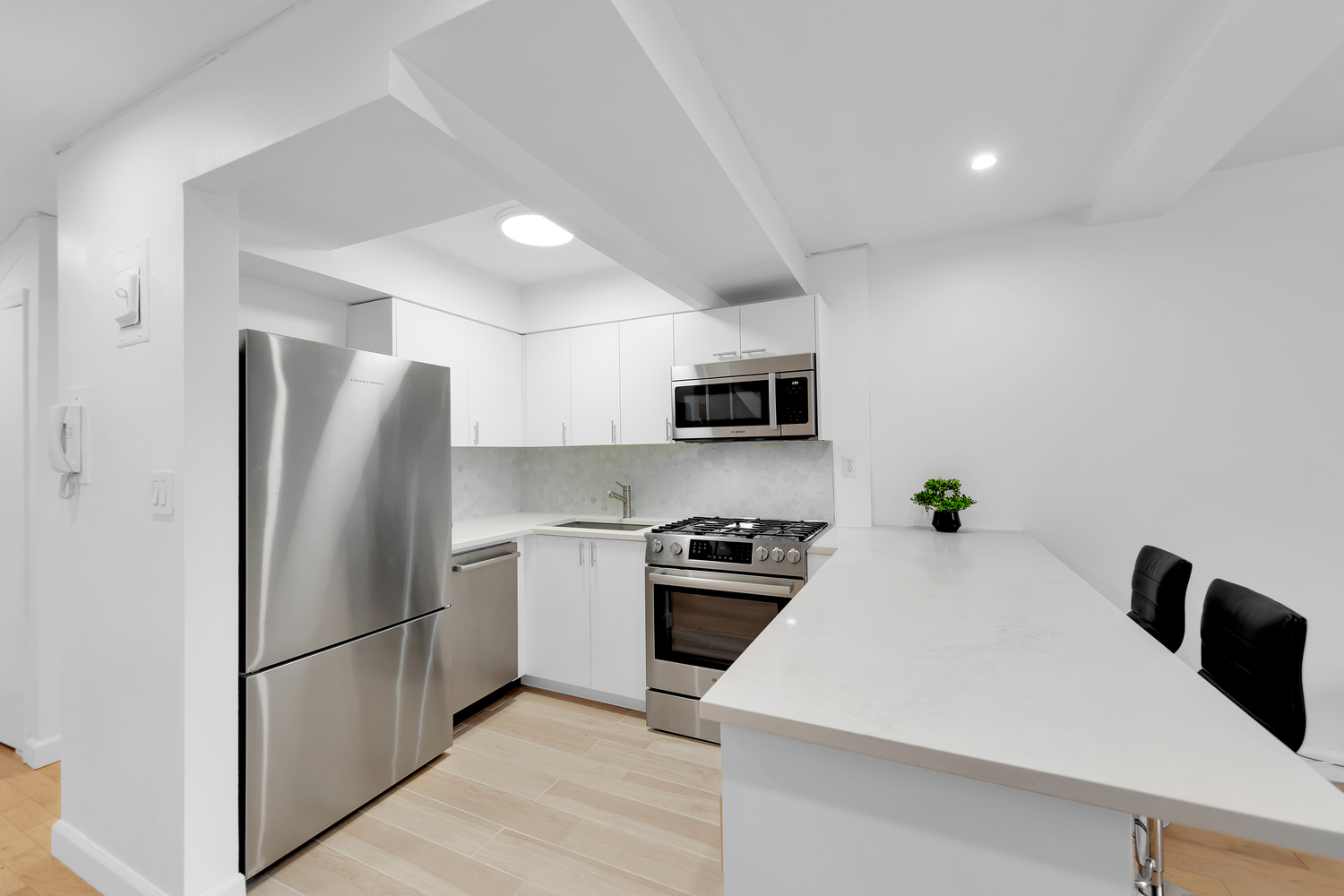 215 East 24th Street, Unit 602 Manhattan, NY 10010 - Photo 4 of 8 a kitchen with stainless steel appliances a refrigerator stove microwave and sink