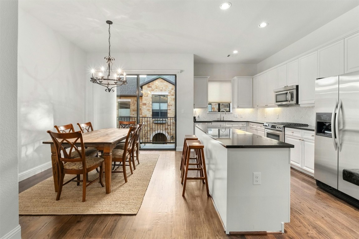 2505 Enfield Road, Unit 4 Austin, TX 78703 - Photo 5 of 19 a kitchen with stainless steel appliances granite countertop a table chairs sink and cabinets