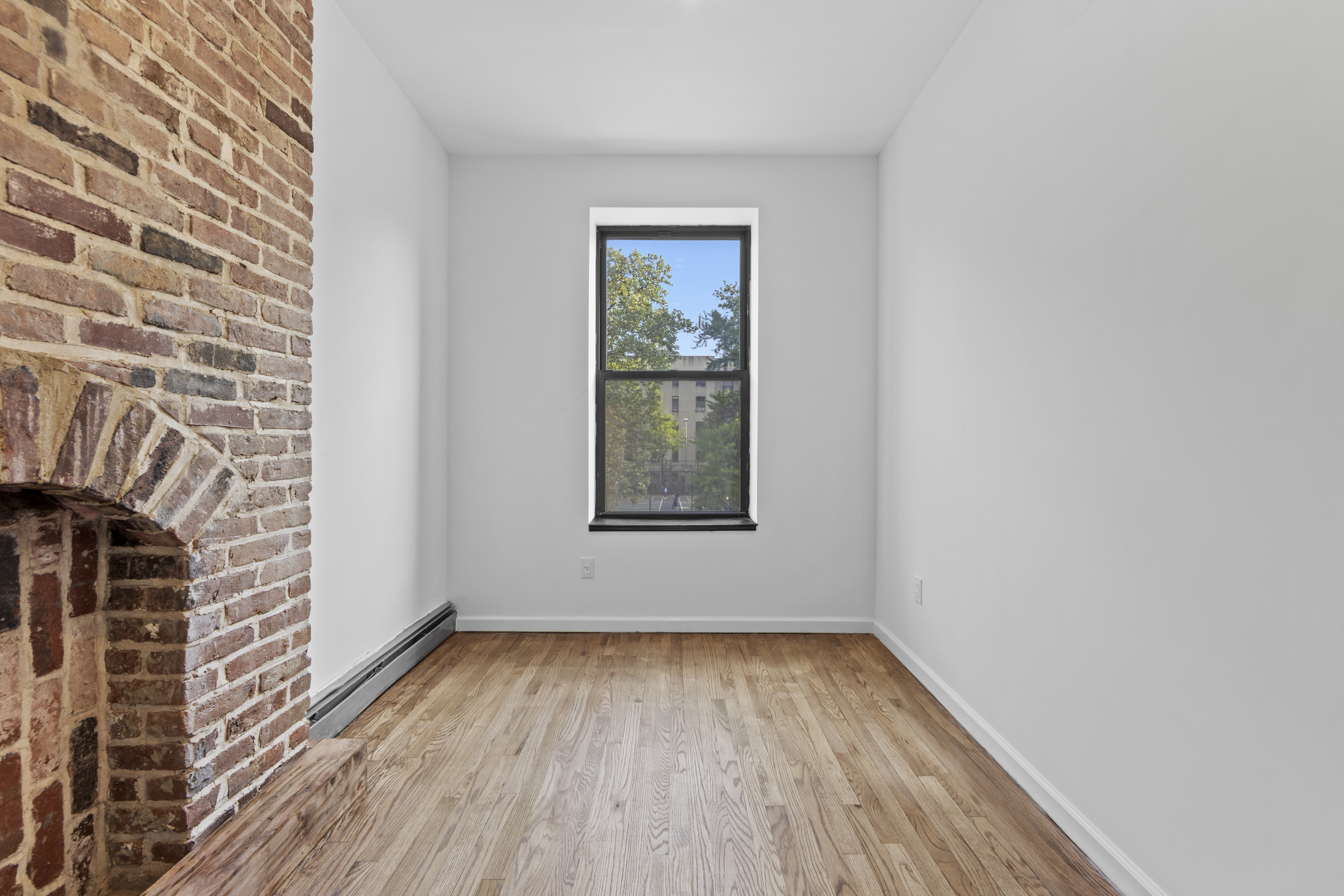 1061 Fulton Street, Unit 3 Brooklyn, NY 11238 - Photo 11 of 14 a view of an empty room with wooden floor and a window