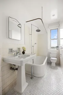 a bath room with a sink a toilet and a mirror
