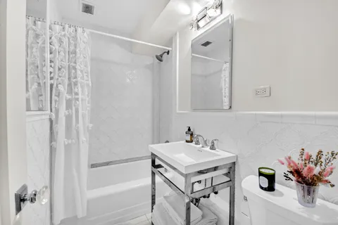 a bathroom with a sink mirror and a shower