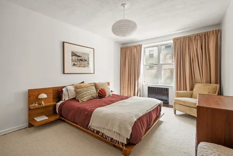 a bedroom with a bed couch and a window