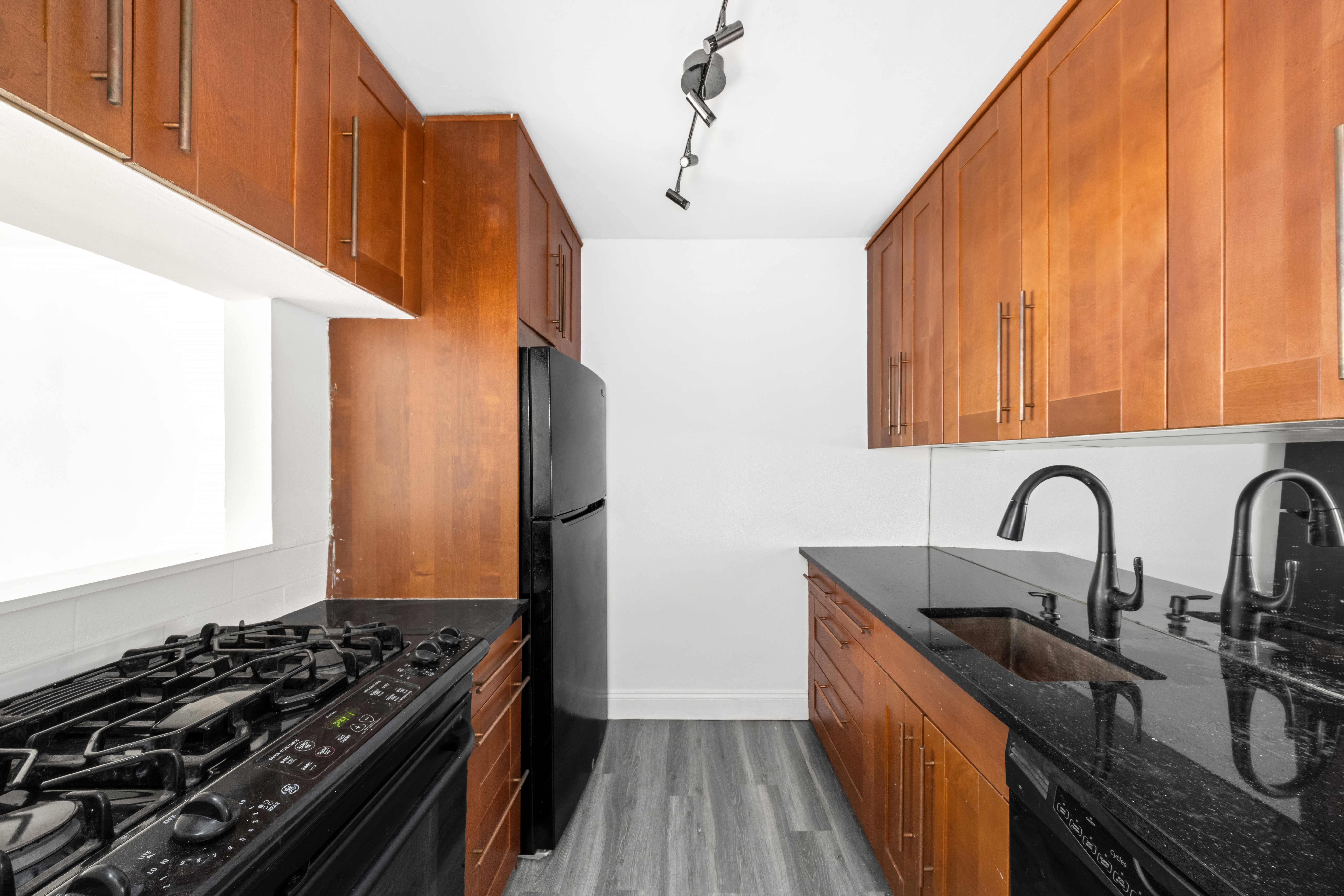 1160 3rd Avenue, Unit 2J Manhattan, NY 10065 - Photo 5 of 8 a kitchen with sink a stove and a refrigerator