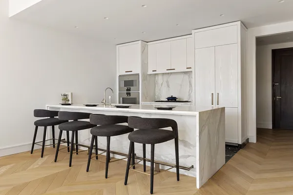 a kitchen with stainless steel appliances granite countertop a table chairs and a refrigerator