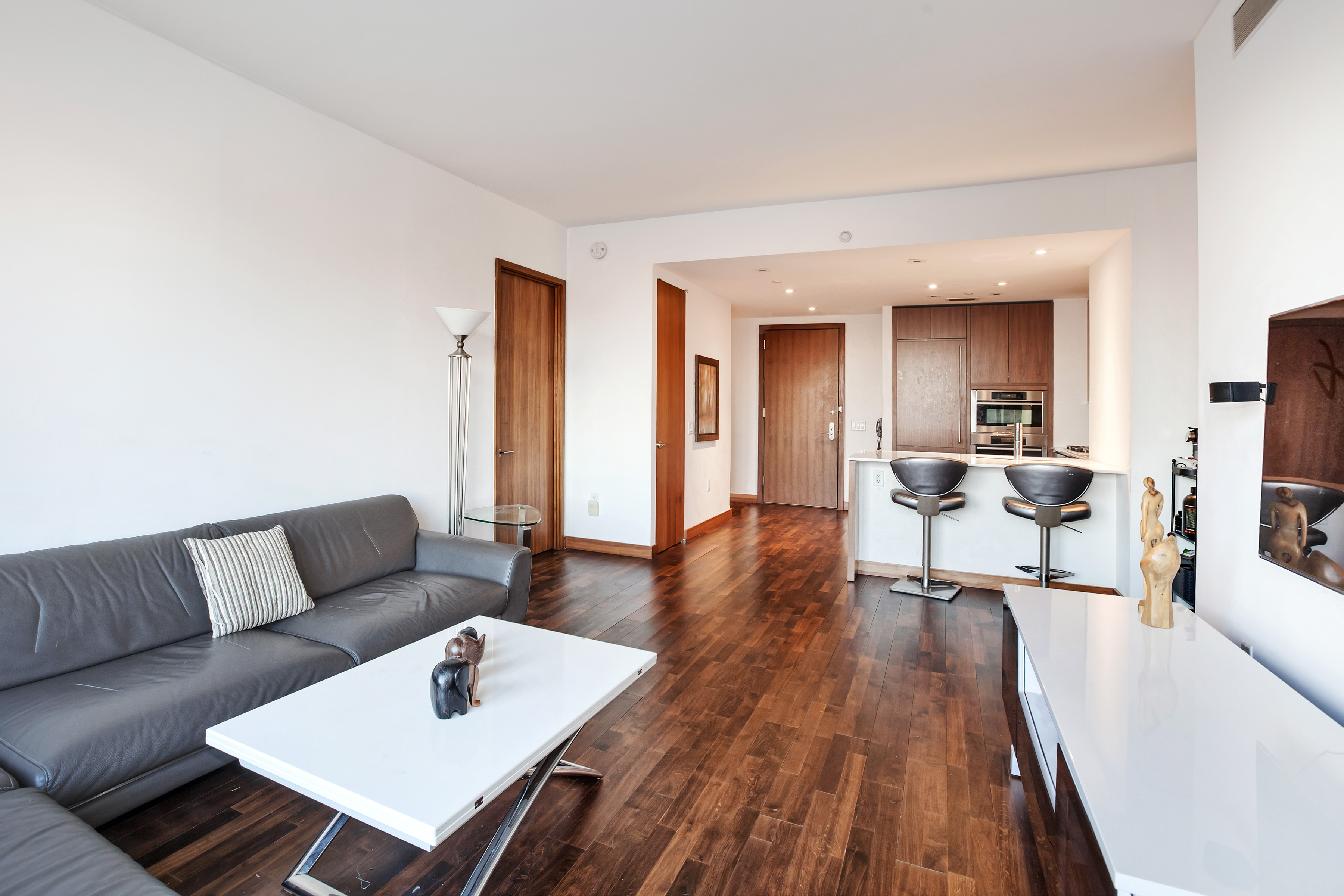 400 5th Avenue, Unit 35C Manhattan, NY 10018 - Photo 2 of 13 a living room with furniture and wooden floor