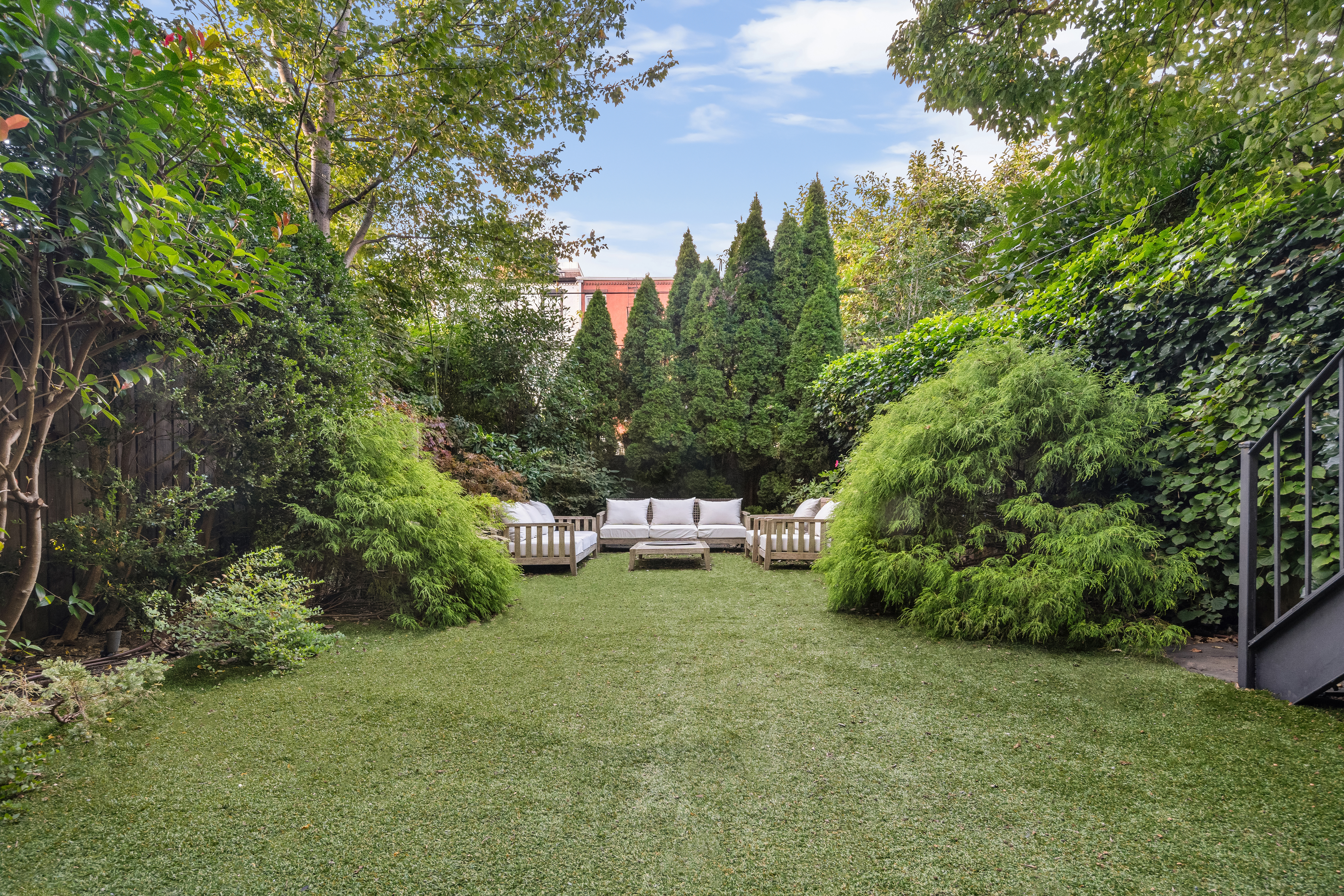 168 Bergen Street Brooklyn, NY 11217 - Photo 23 of 25 a view of a garden with a bench and trees