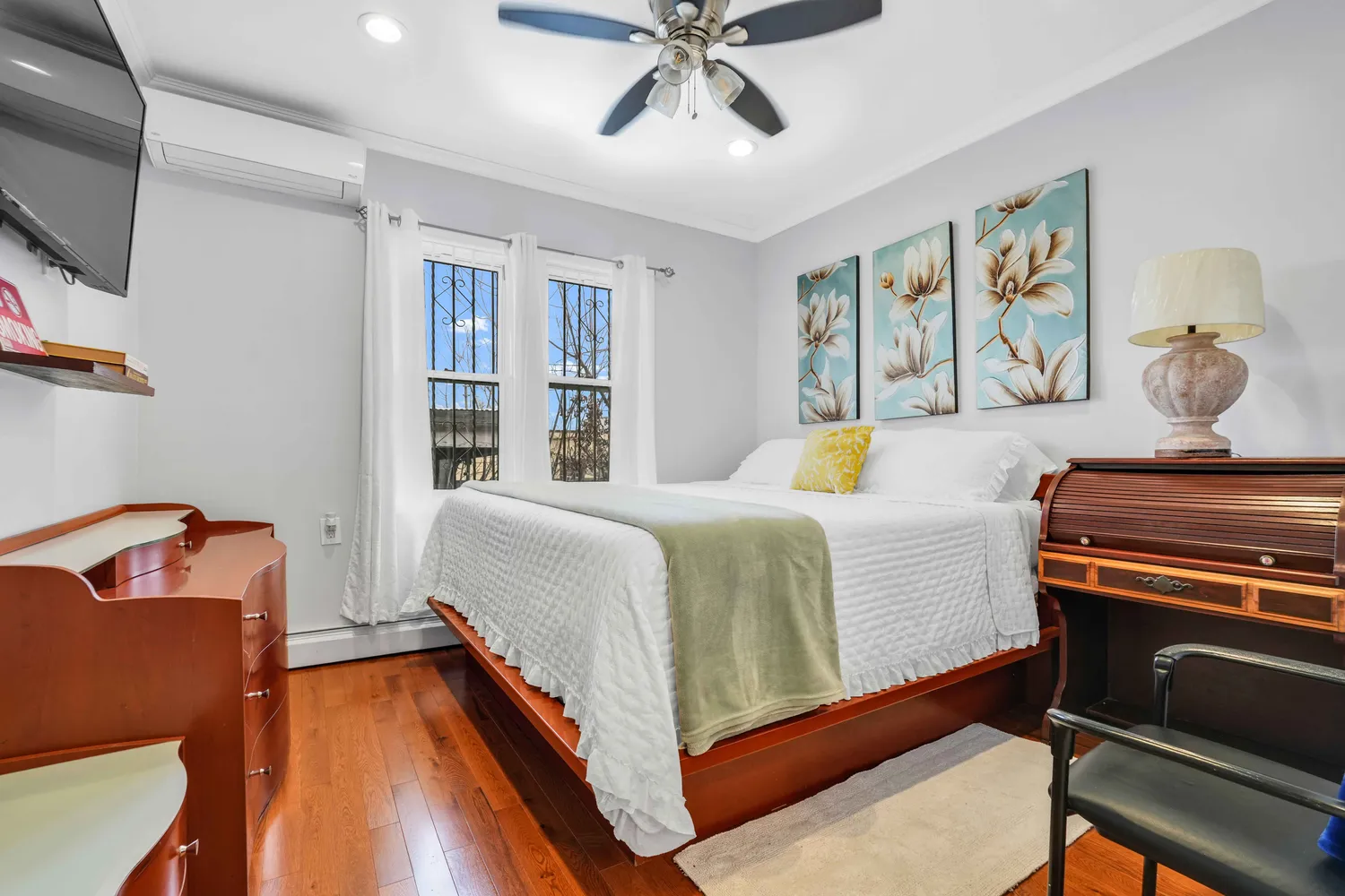 a bedroom with furniture and a flat screen tv