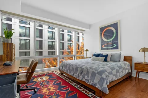 a bedroom with a bed and a table in it with wooden floor