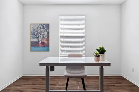 a view of a workspace with furniture and wooden floor