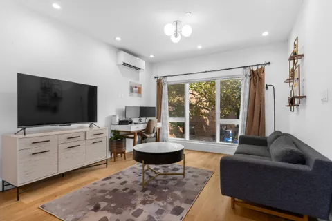 a living room with furniture a flat screen tv and a large window