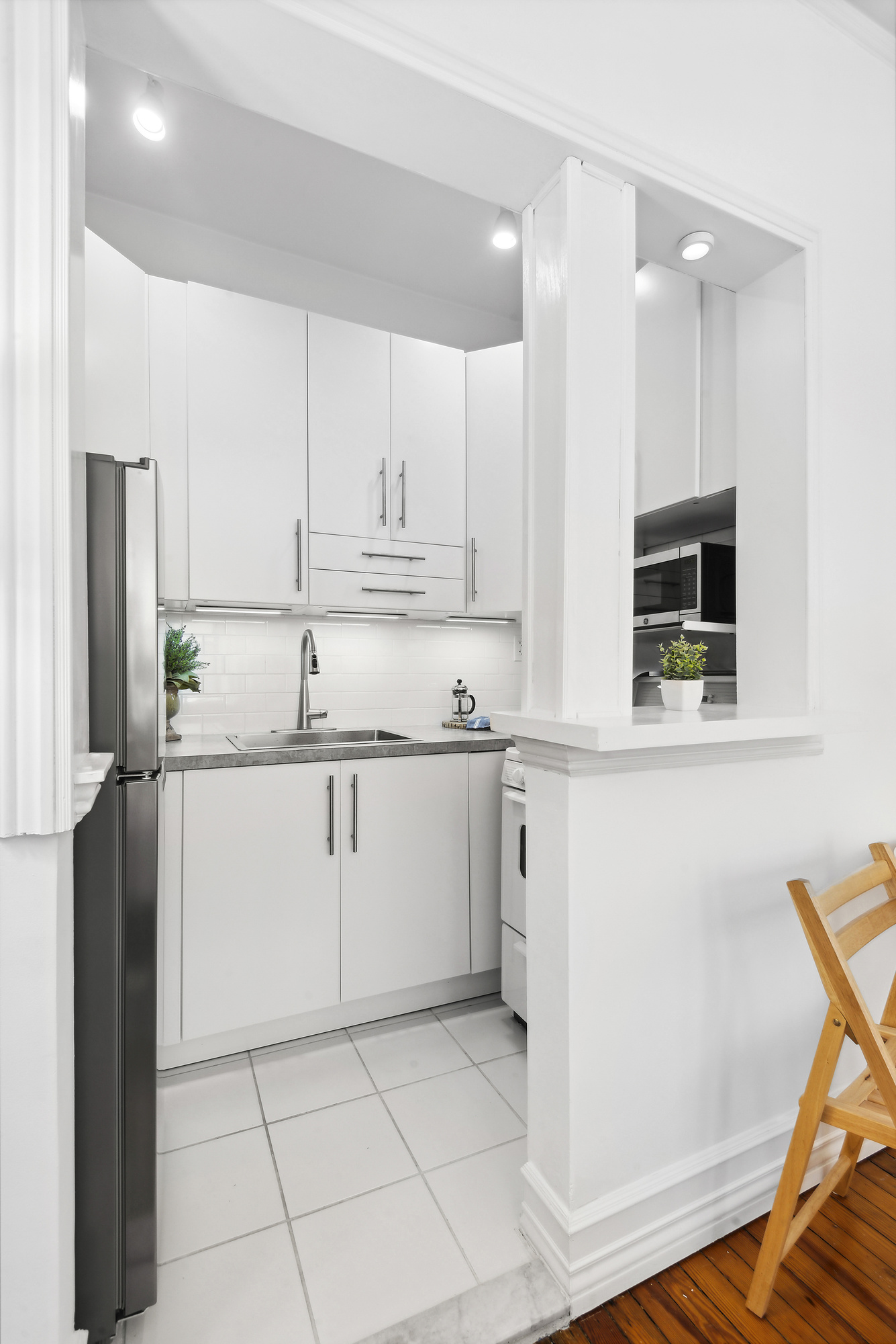 293 Riverside Drive, Unit 5B Manhattan, NY 10025 - Photo 5 of 10 a kitchen with white cabinets and refrigerator
