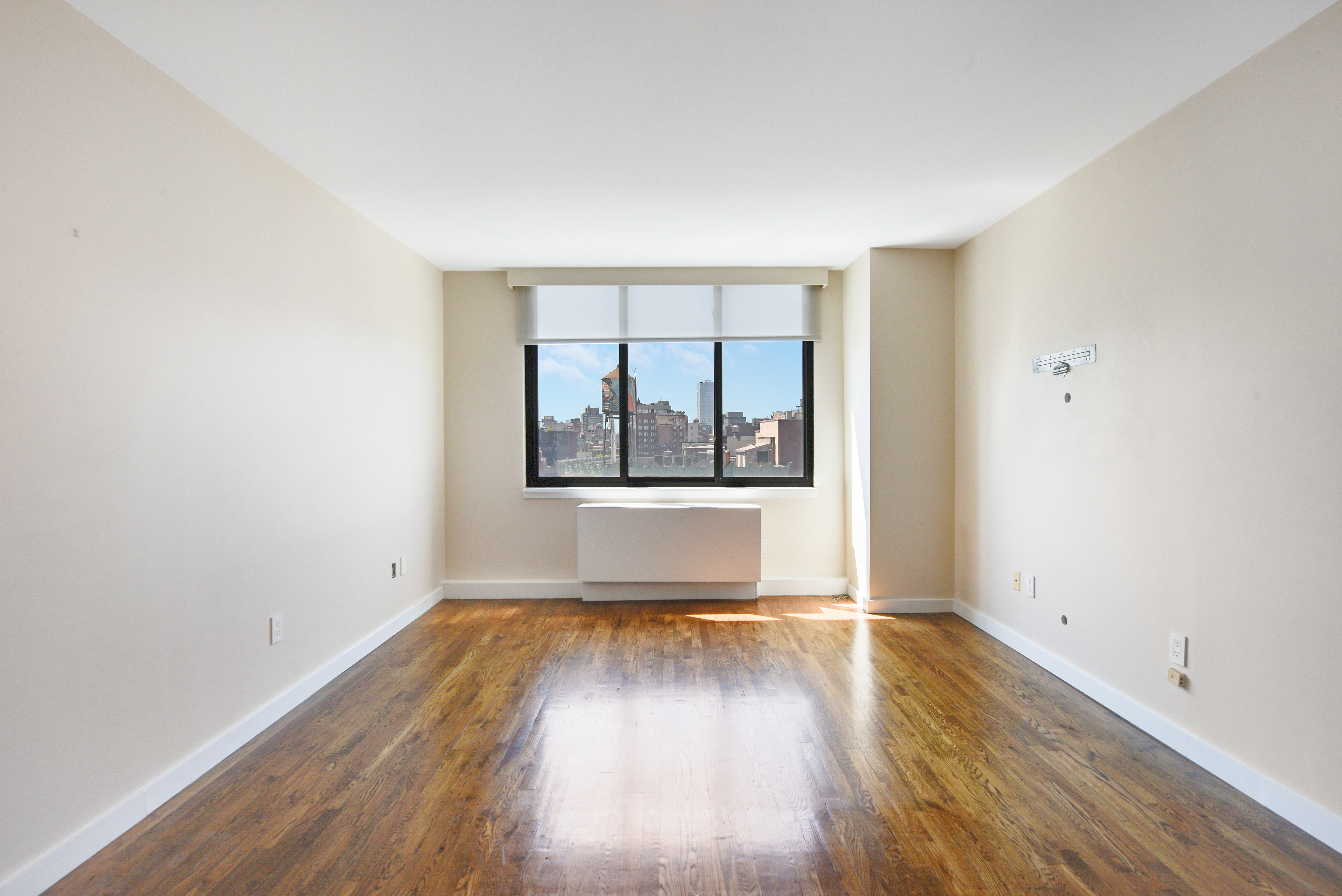 199 Bowery, Unit 11F Manhattan, NY 10002 - Photo 2 of 13 an empty room with wooden floor and windows
