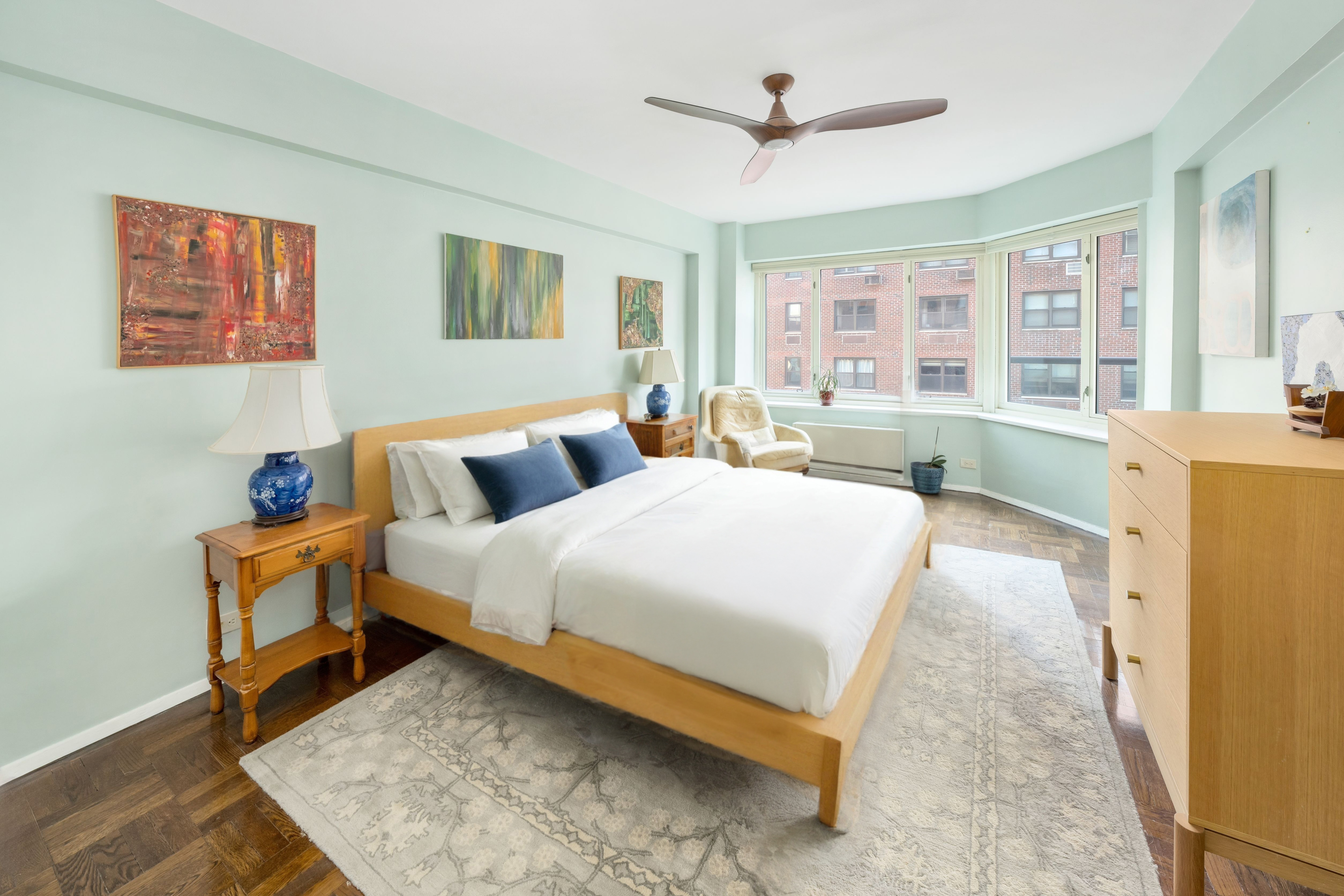 36 Sutton Place South, Unit 13D Manhattan, NY 10022 - Photo 5 of 9 a bed room with a bed and a couch