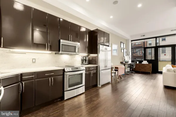 a kitchen with stainless steel appliances granite countertop wooden cabinets a refrigerator a stove a sink and a microwave