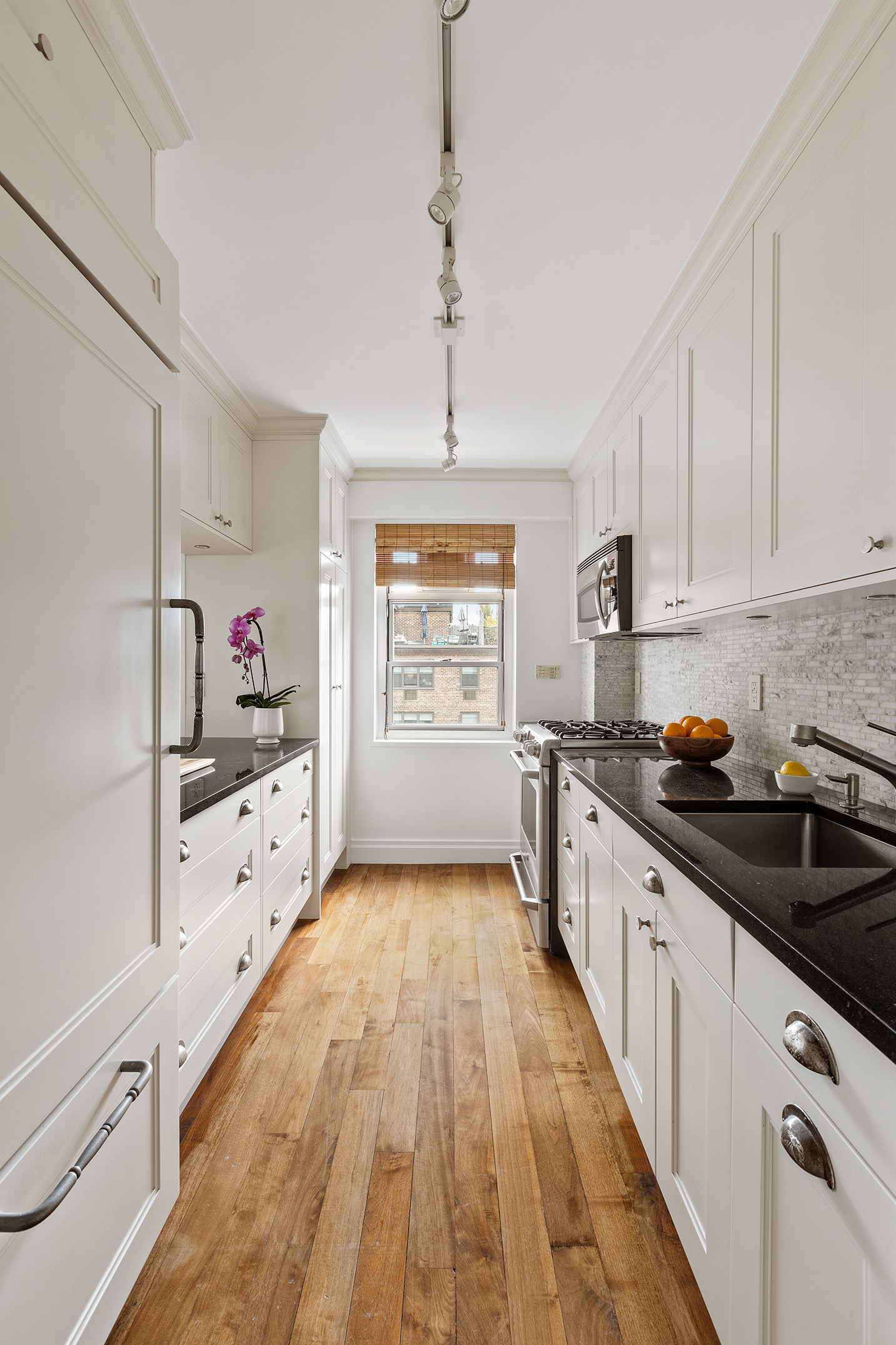 70 East 10th Street, Unit 14P Manhattan, NY 10003 - Photo 2 of 8 a kitchen with granite countertop white cabinets and white appliances