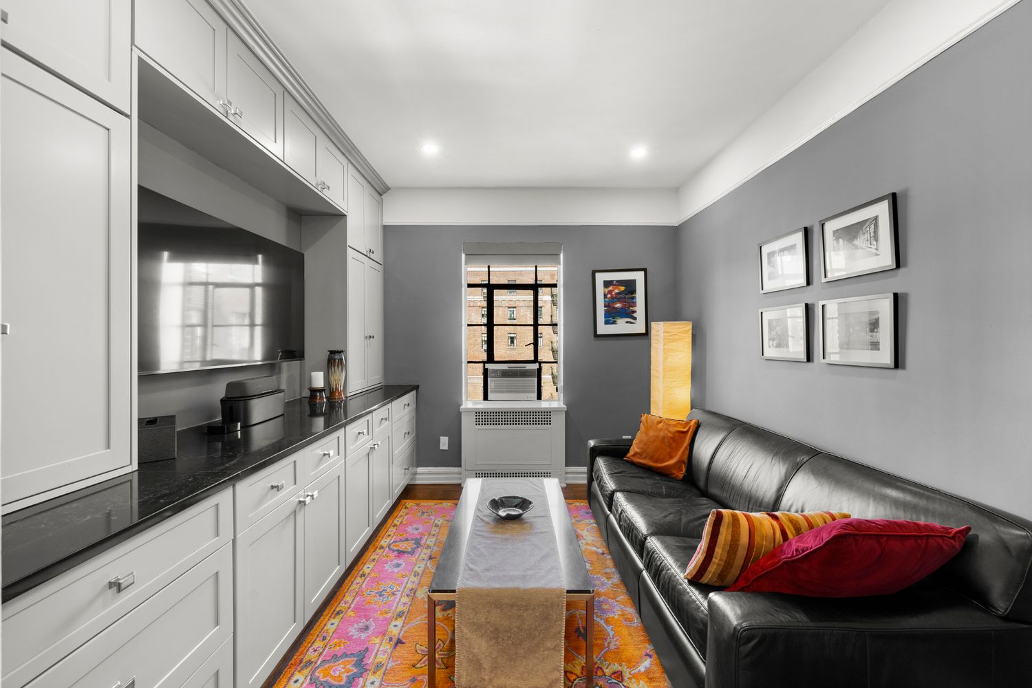 a living room with furniture flat screen tv and a large window