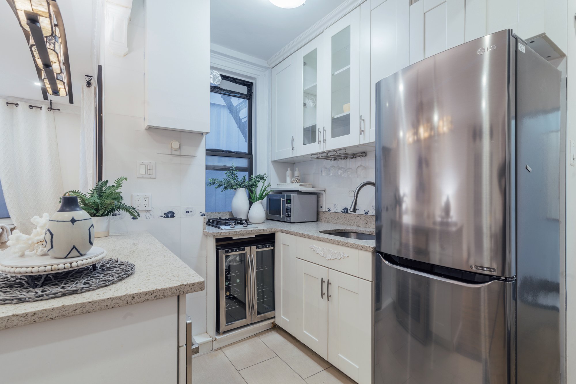162 West 56th Street, Unit 1102 Manhattan, NY 10019 - Photo 3 of 12 a kitchen with stainless steel appliances granite countertop a refrigerator and a sink