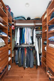 a view of walk in closet with clothes and shoes