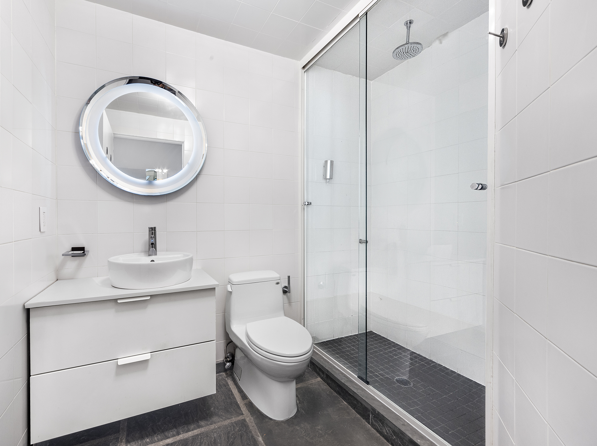 25 Leonard Street, Unit 2 New York, NY 10013 - Photo 10 of 12 a bathroom with a toilet a sink and a mirror