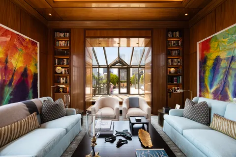 a living room with furniture a bookshelf and a large window