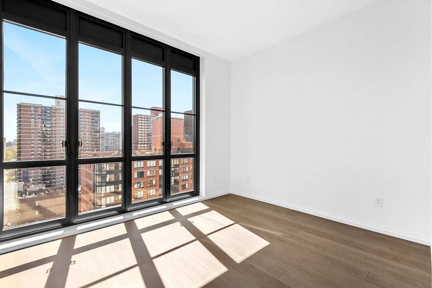 250 West 96th Street, Unit 18C Manhattan, NY 10025 - Photo 11 of 28 a view of an empty room with wooden floor and a window
