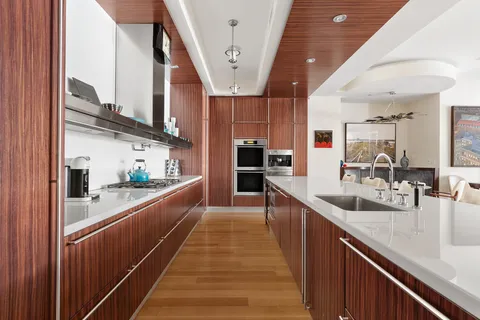 a large kitchen with stainless steel appliances kitchen island granite countertop a large counter top and wooden cabinets