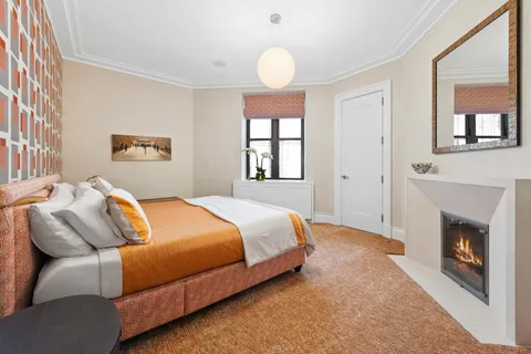 a bedroom with a bed and a fireplace