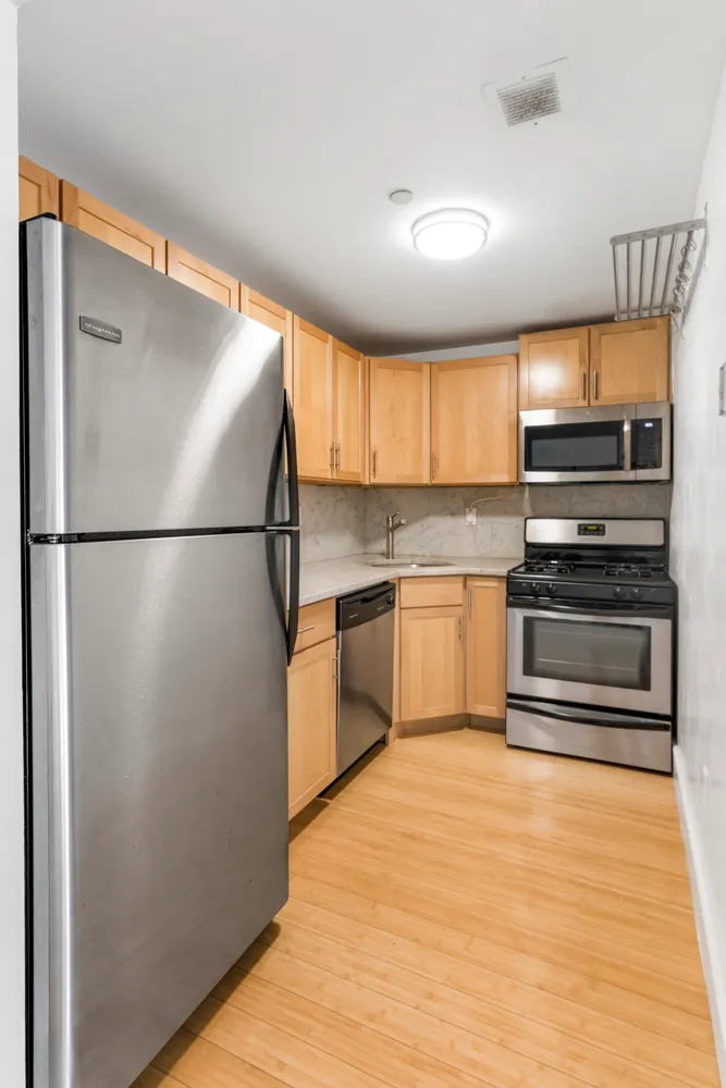 a kitchen with granite countertop a refrigerator and a stove top oven