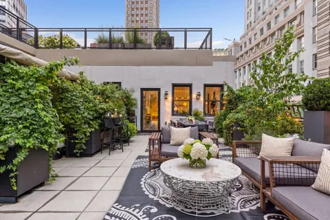 a view of a patio with couches table and chairs and potted plants