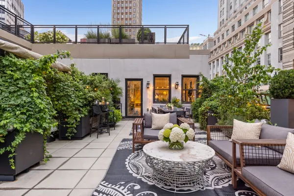 a view of a patio with couches table and chairs and potted plants