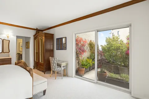 a bedroom with a bed and large windows