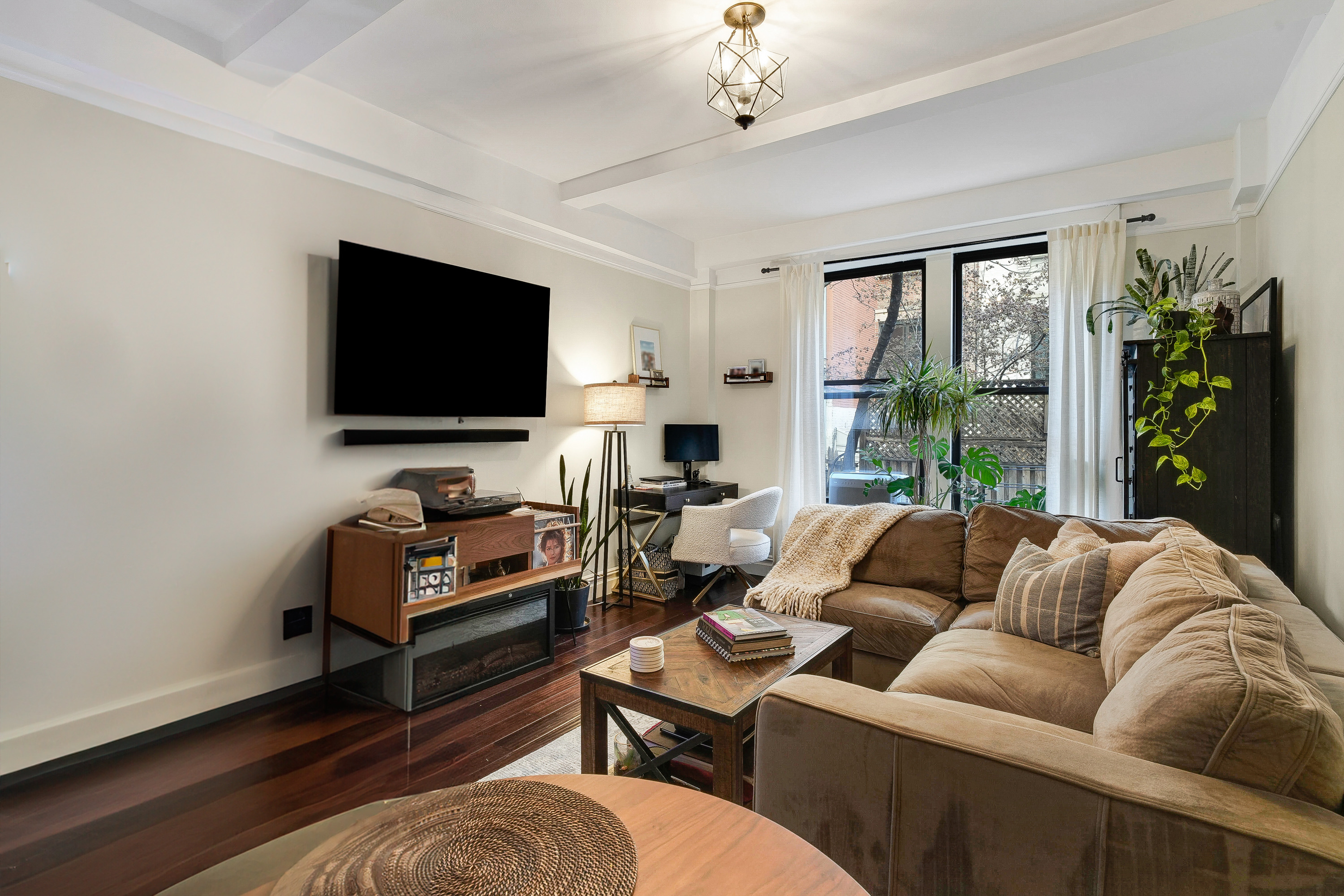 a living room with furniture a flat screen tv and a large window