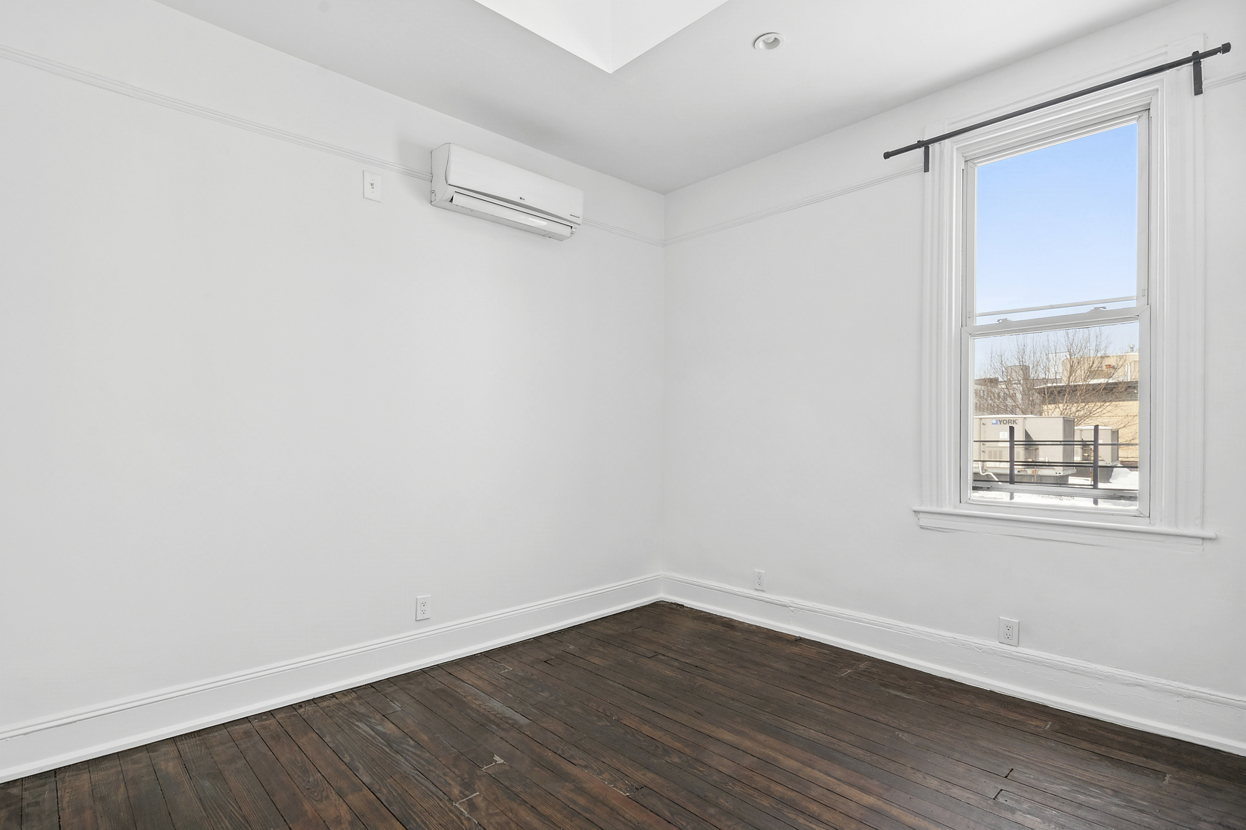 239 East 23rd Street, Unit 2 Brooklyn, NY 11226 - Photo 6 of 8 an empty room with wooden floor and windows