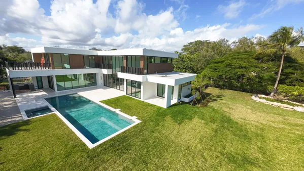 an aerial view of a house with swimming pool garden and patio