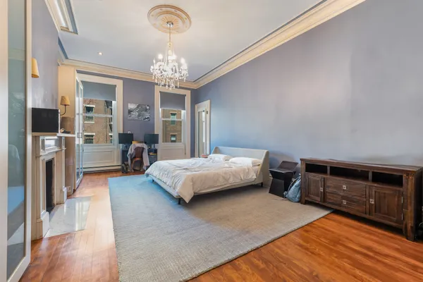 a spacious bedroom with a bed and a chandelier