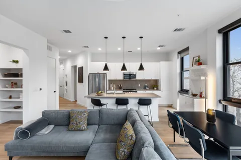 a living room with stainless steel appliances kitchen island granite countertop furniture and a view of kitchen