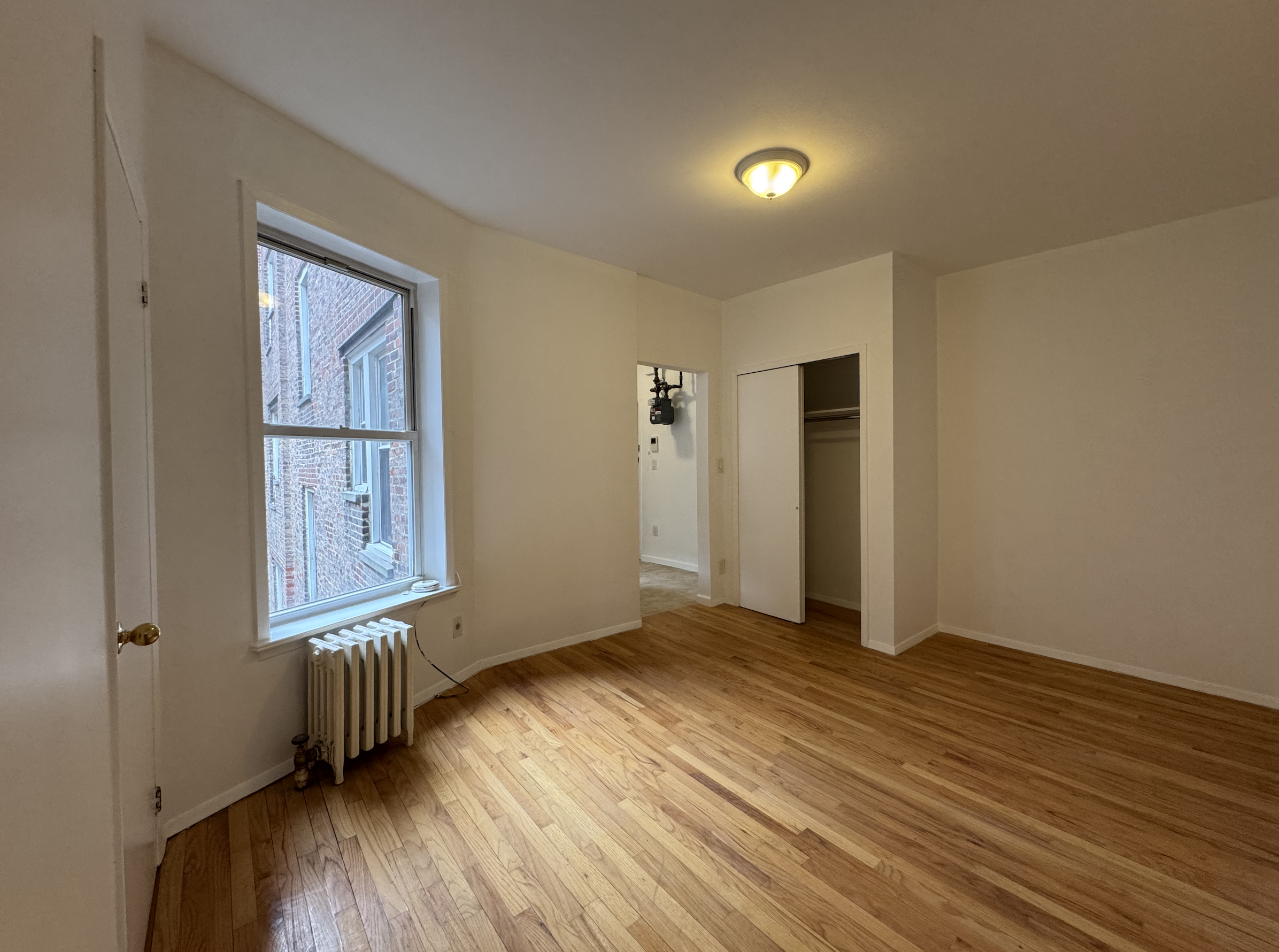 451 West 44th Street, Unit 63 Manhattan, NY 10036 - Photo 9 of 33 an empty room with wooden floor and windows