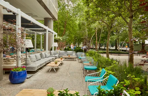 a view of a patio with couches table and chairs and potted plants