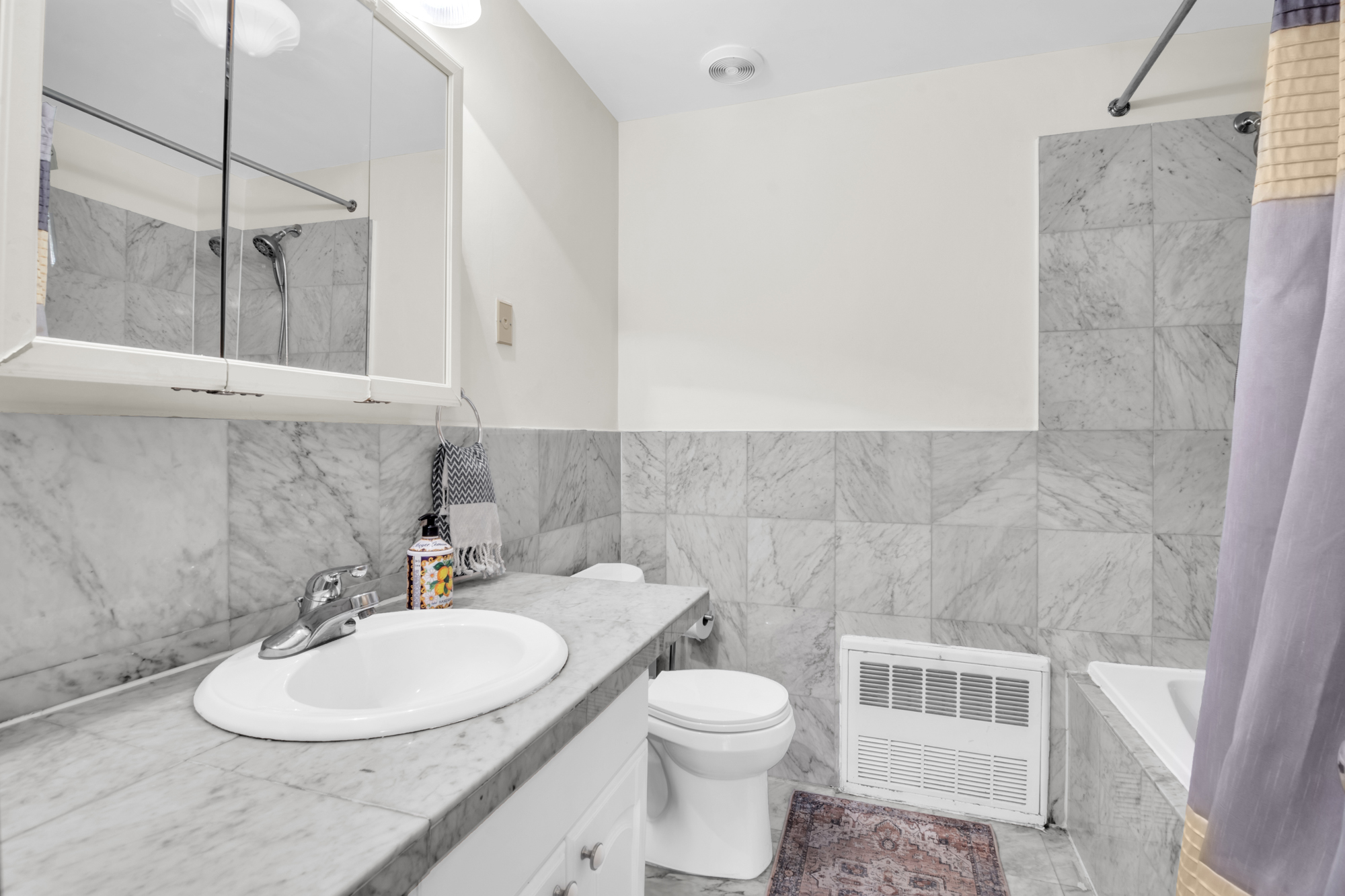 137 West 126th Street, Unit 1 Manhattan, NY 10027 - Photo 7 of 12 a bathroom with a sink a toilet and a mirror