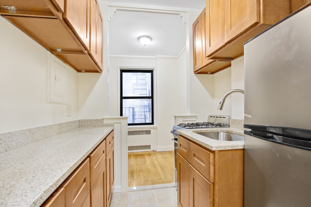 145 East 22nd Street, Unit 3D Manhattan, NY 10010 - Photo 3 of 6 a kitchen with a sink stove and cabinets