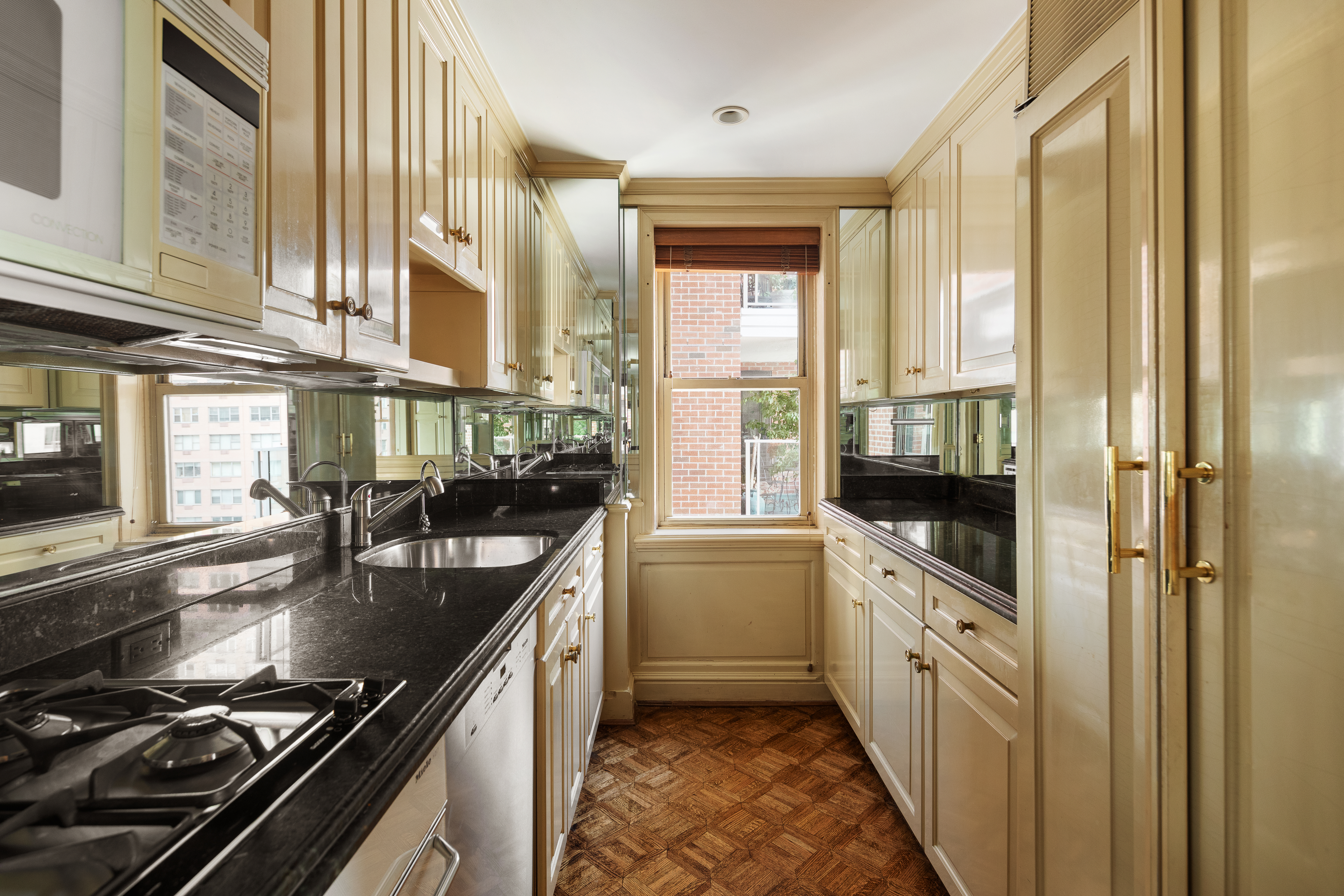 50 Sutton Place South, Unit 11H Manhattan, NY 10022 - Photo 6 of 10 a kitchen with stainless steel appliances a sink stove and cabinets