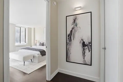 a view of a bedroom with a bed and a painting on the wall