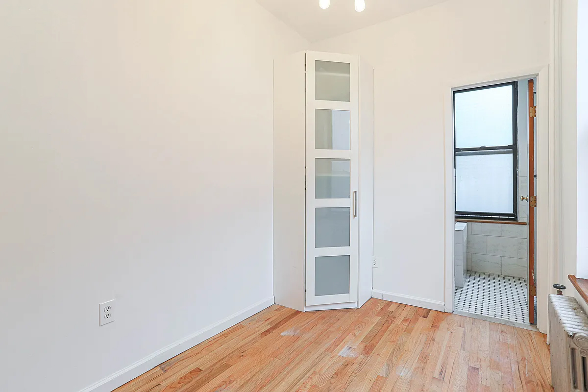 199 Java Street Brooklyn, NY 11222 - Photo 22 of 32 a view of empty room with wooden floor and fan
