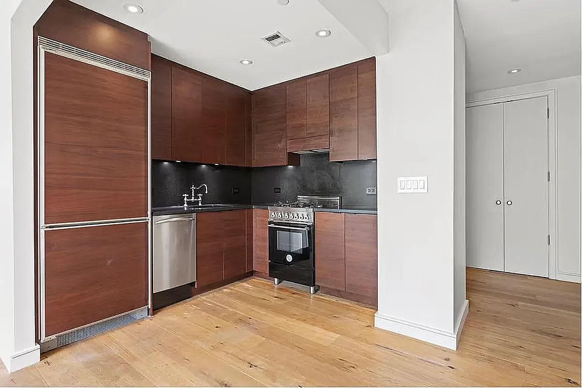 540 West 28th Street, Unit 8A Manhattan, NY 10001 - Photo 3 of 12 a kitchen with a refrigerator and a stove