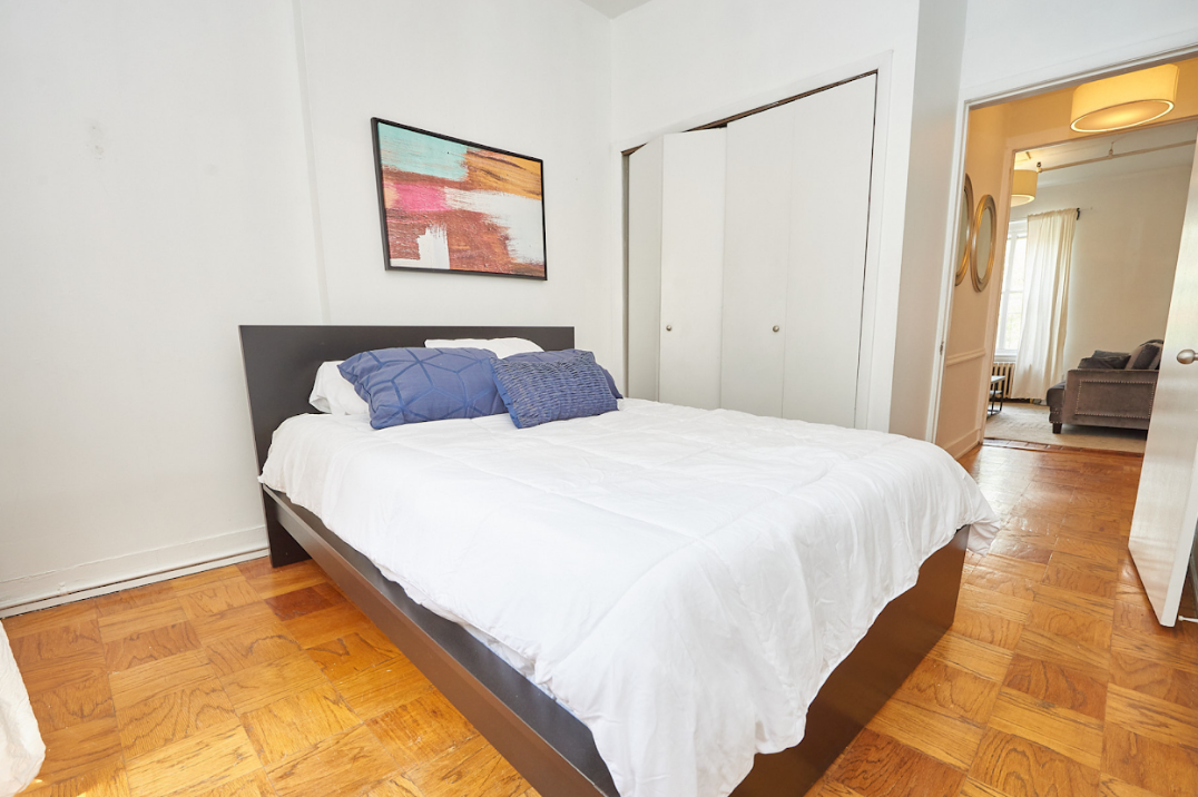 120 East 10th Street, Unit 3 Manhattan, NY 10003 - Photo 9 of 14 a spacious bedroom with a bed and a painting on the wall