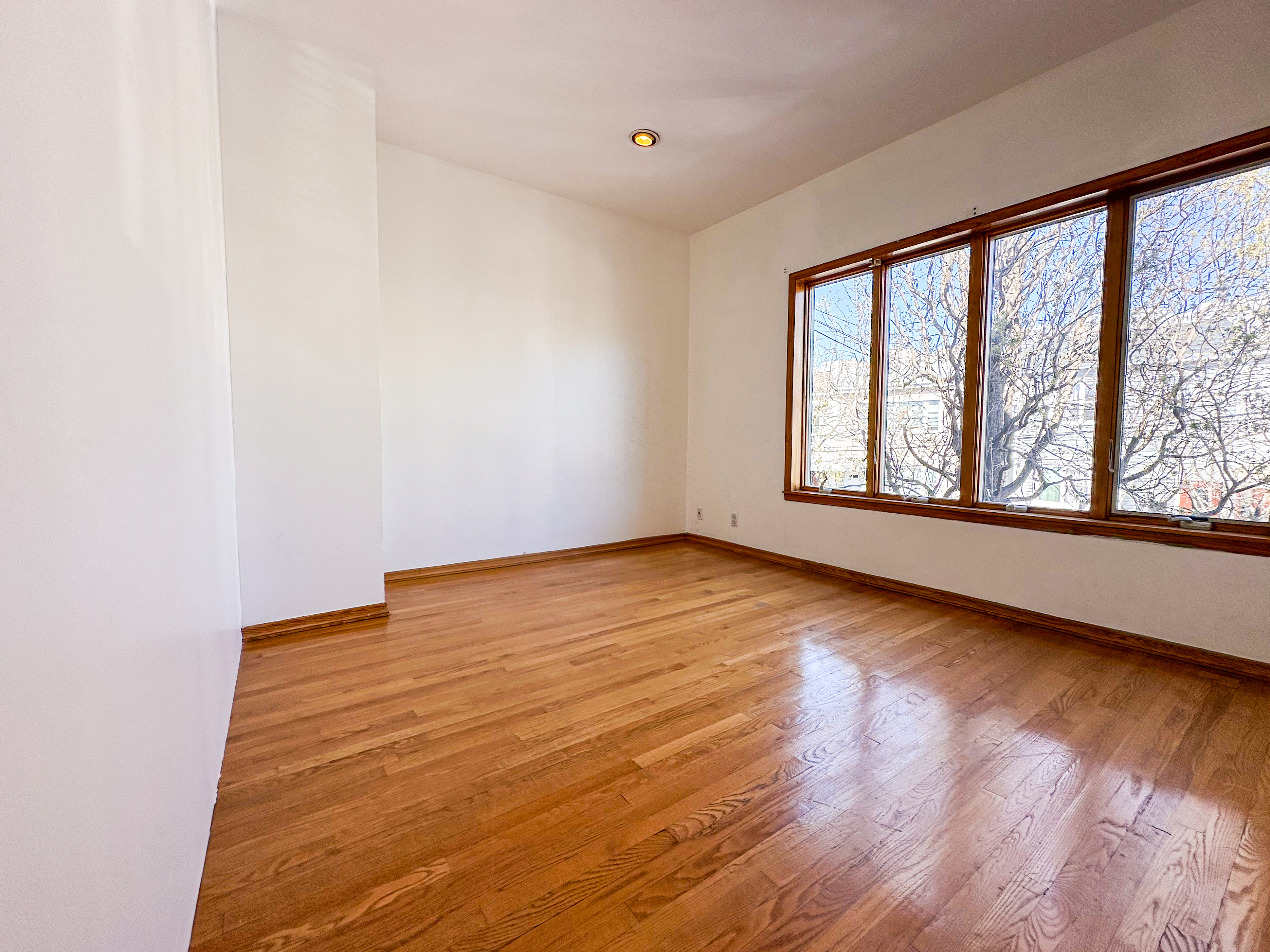 66-42 Clinton Avenue, Unit 2 Queens, NY 11378 - Photo 8 of 14 wooden floor in an empty room with a window